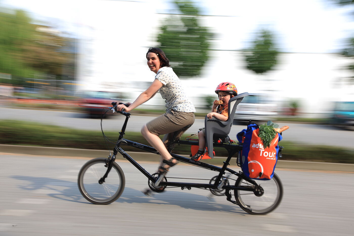 Eine Frau mit Kleinkind auf dem Rad.