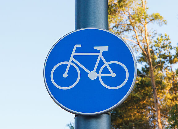 Ein blaues Schild mit einem Fahrradsymbol, das einen benutzungspflichtigen Radweg anzeigt.