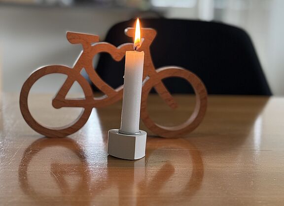 Foto zur Schweigeminute für #Natenom brennende Kerze vor Miniatur-Fahrrad aus Holz