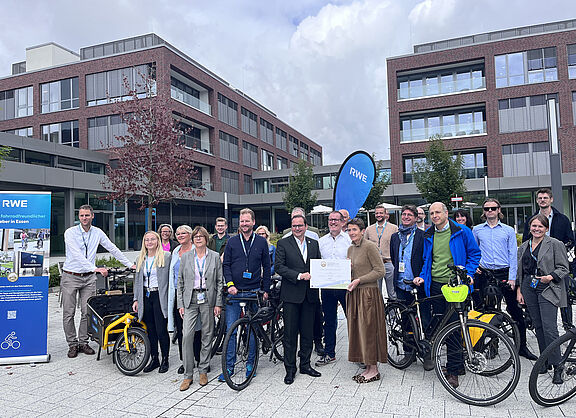 Fahrradfahrende vor einem Firmengebäude