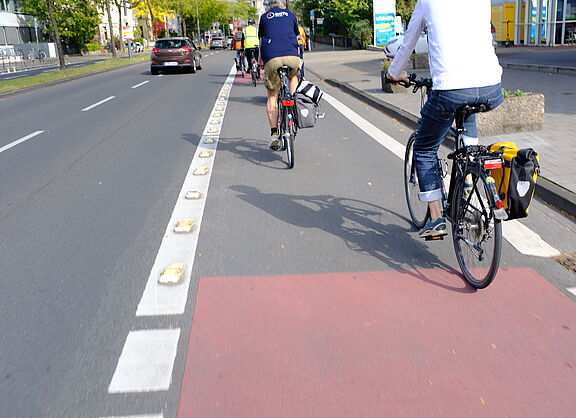 Die Stadtverwaltung Köln wandelt auf vielen Stücken der Ringe eine Fahrspur in einen Radfahrstreifen um. Inzwischen sind weite Strecken der Ringe umgewandelt. Noch besteht aber Handlungsbedarf. Der Radverkehr hat bereits messbar zugenommen. Die an wenigen Orten eingesetzten Trennelemente erfüllen ihren Zweck (wie man unschwer erkennen kann) bisher nicht. 